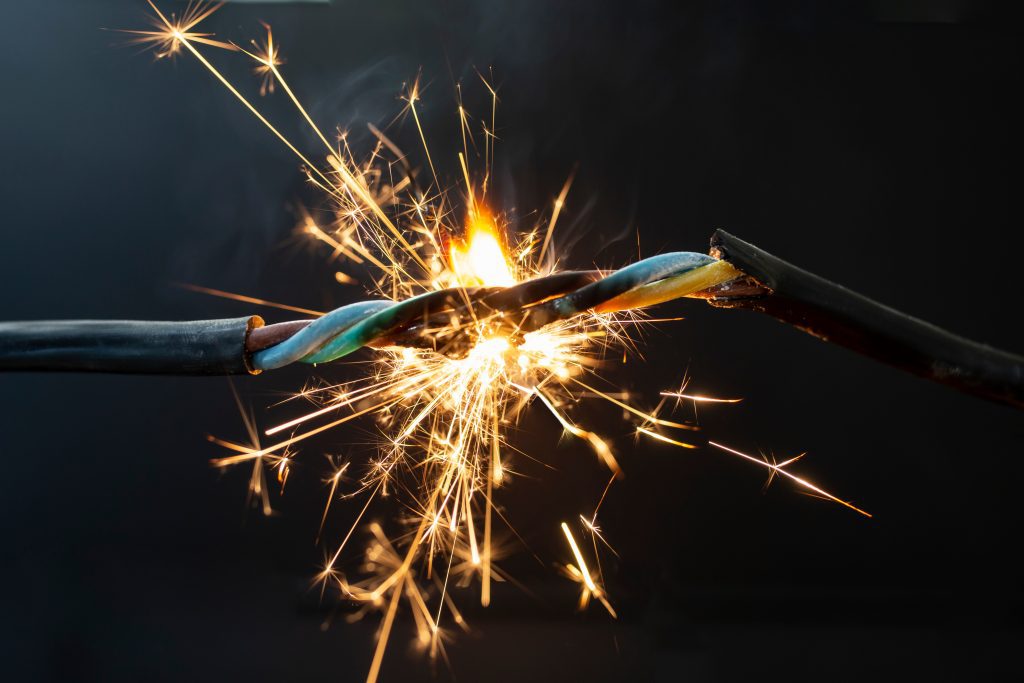 flame smoke and sparks on an electrical cable, fire hazard concept, soft focus close up